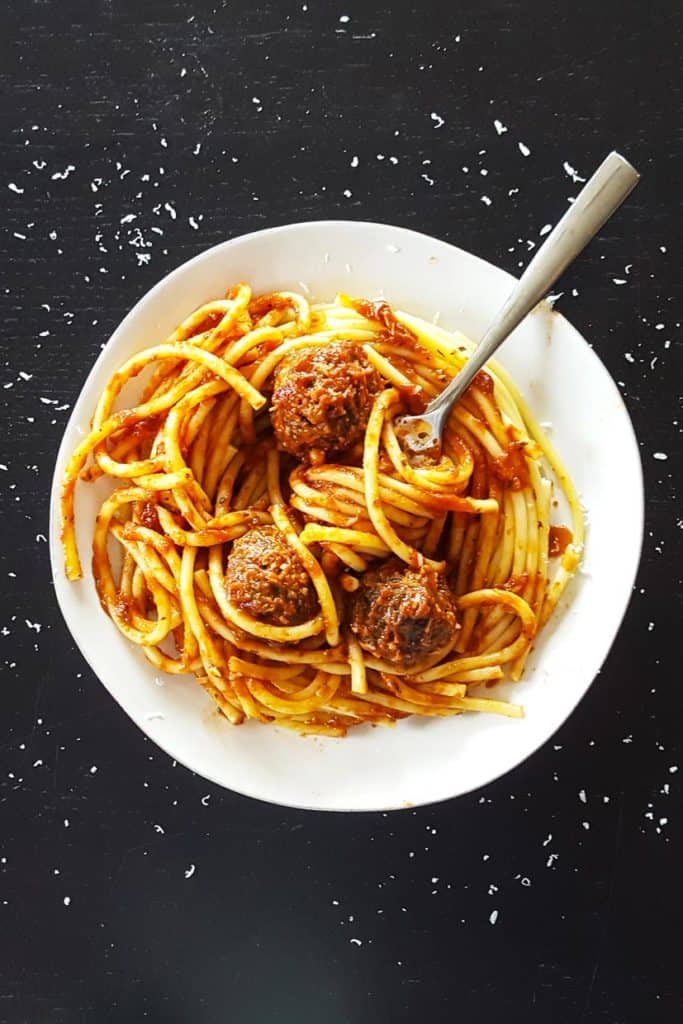 Spaghetti and meatballs in white bowl