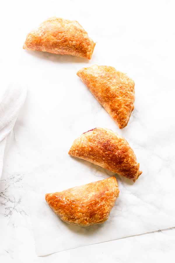 Tasty Air Fryer berry hand pies on a white sheet.