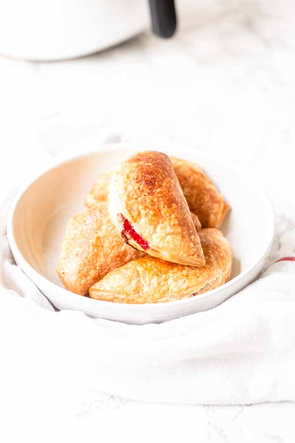 Easy to make Air Fryer berry hand pies in a white bowl. A tasty snack.