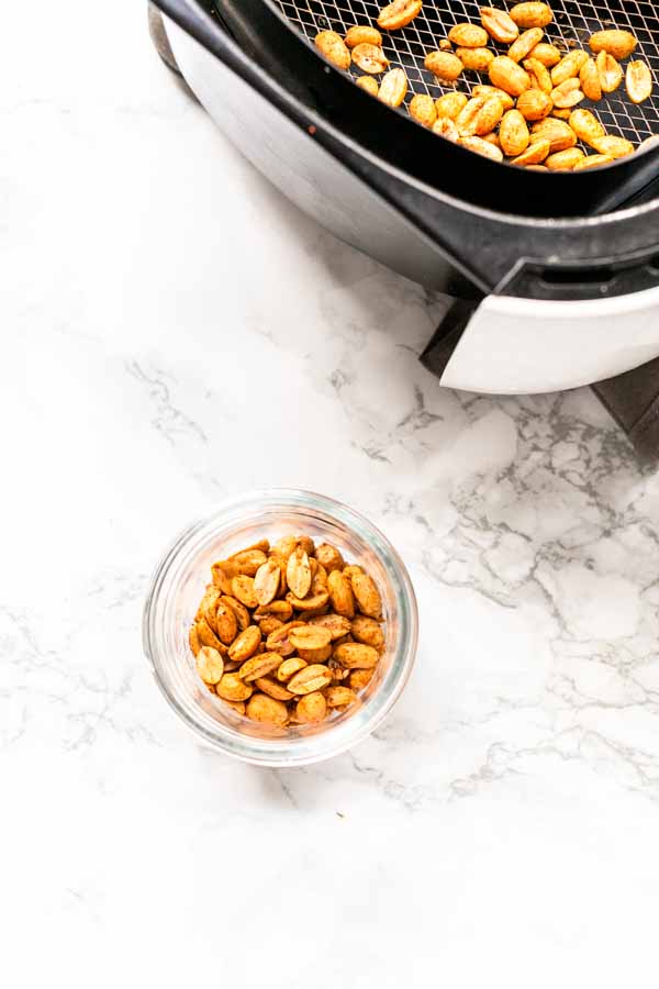 Air Fryer roasted peanuts in a glass jar. Ready to be served as a snack or use in your recipes. They can also be storer for a long time.