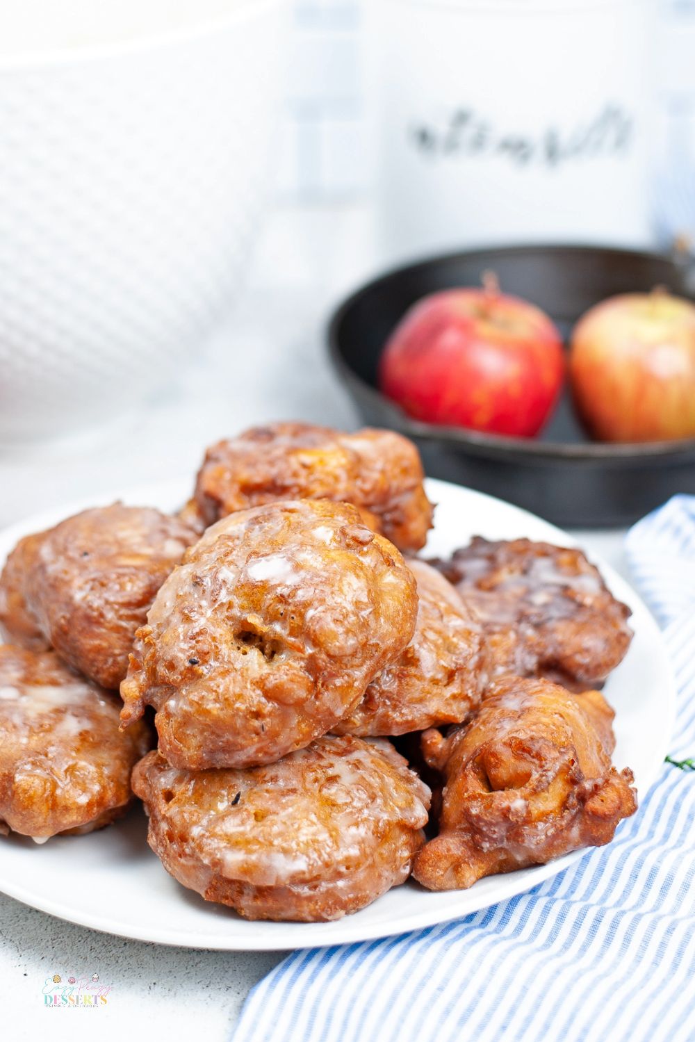Close up image of fried homemade apple fritters with sugar glaze