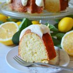 lemon bundt cake on white plate with lemons