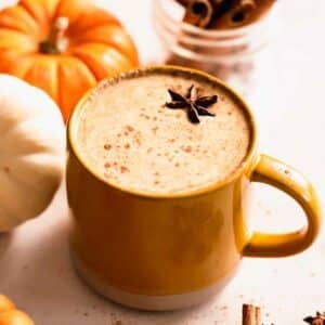 pumpkin spice latte in mug with cinnamon sticks and star anise