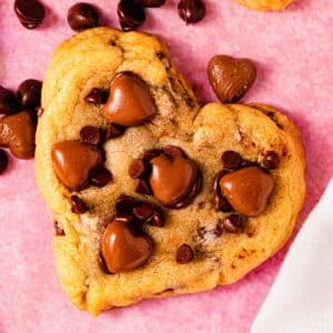heart shaped chocolate chip cookie on counter with chocolate hearts