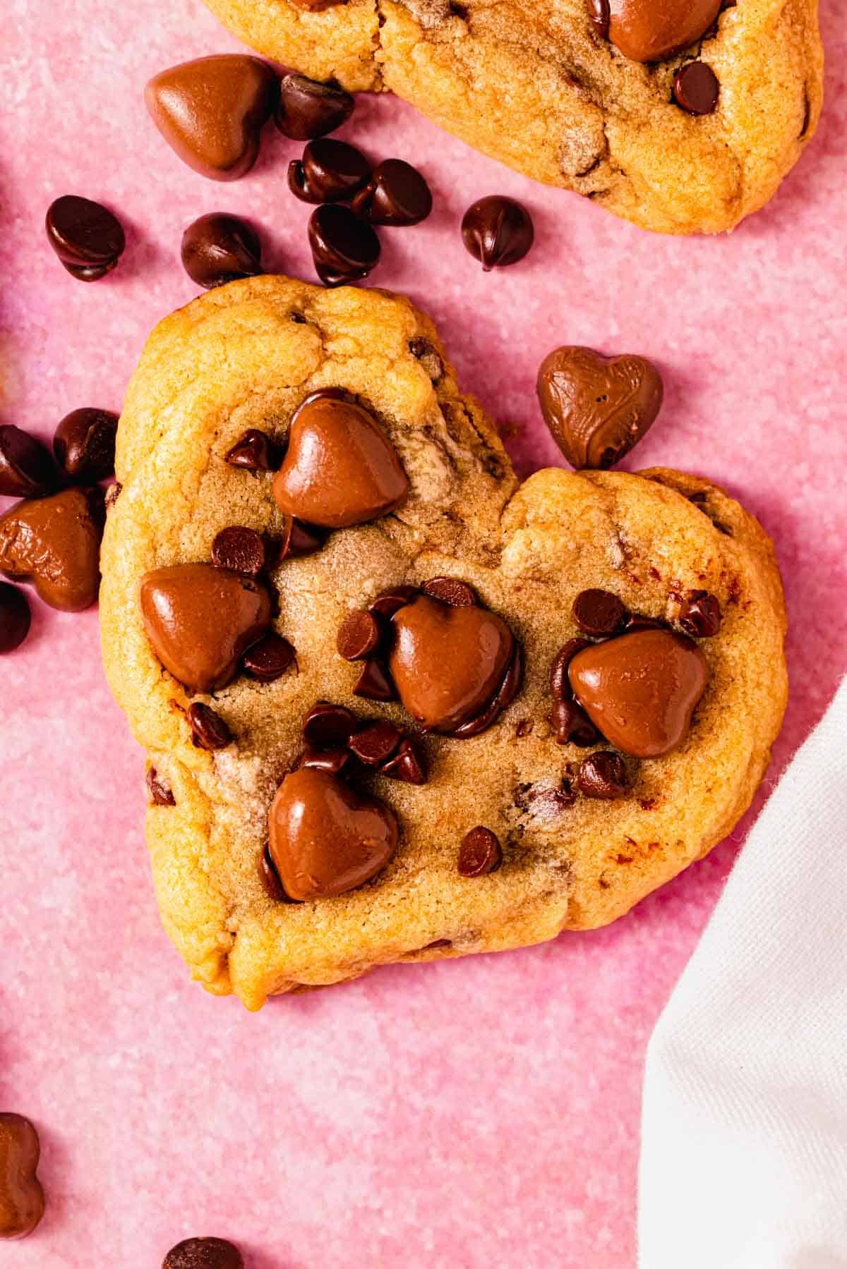heart shaped chocolate chip cookie on counter with chocolate hearts