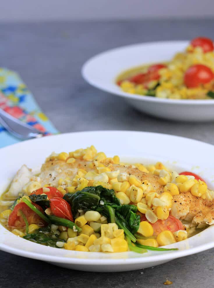 Fsh with corn and tomatoes in a bowl.