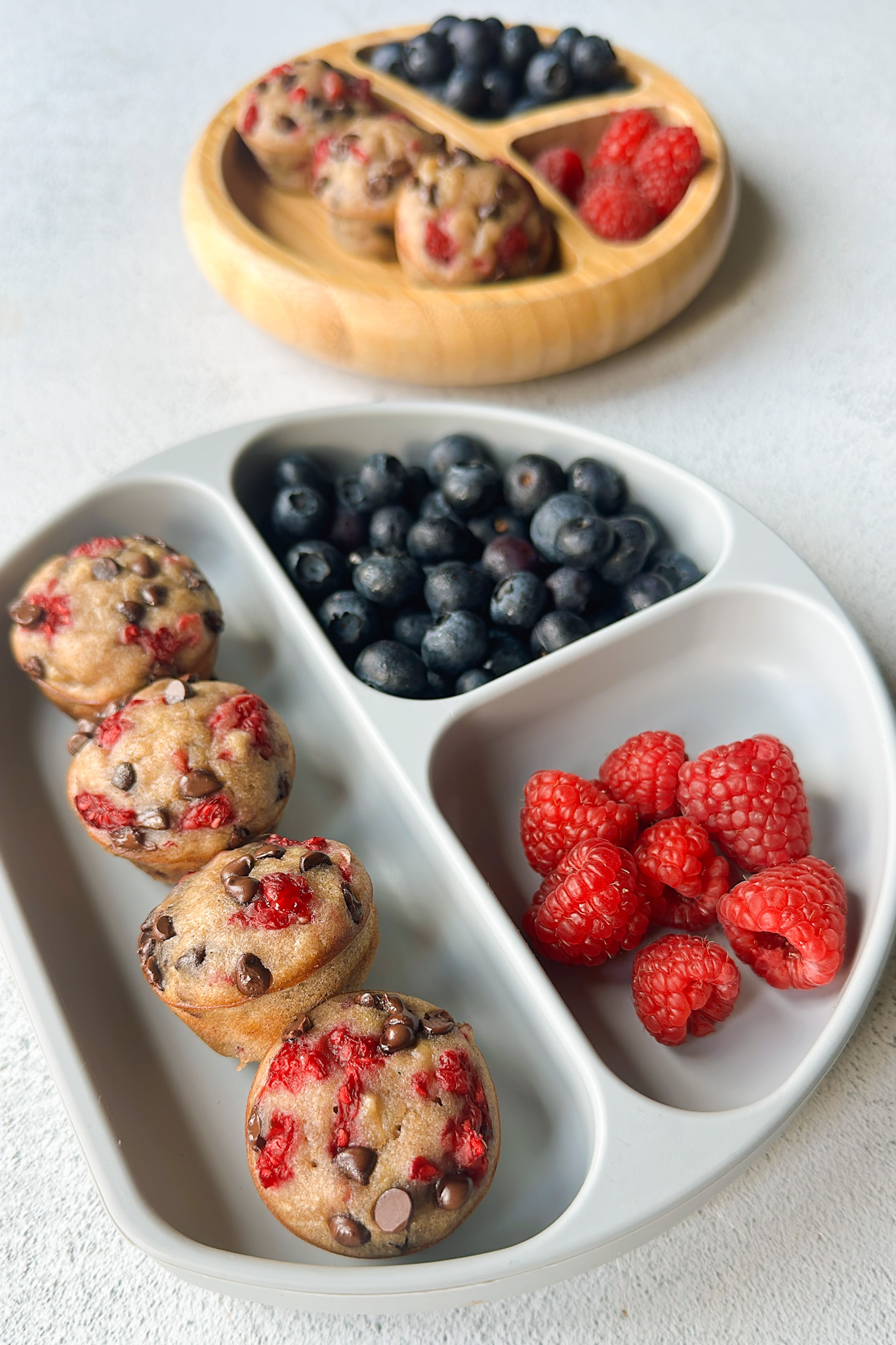 Raspberry banana muffins served with berries.
