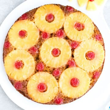 Best Pineapple Upside Down Cake With Maraschino Cherries on White Dish.