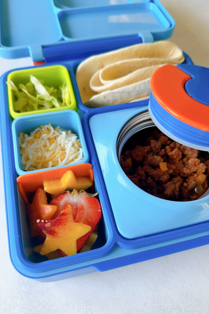 Ground beef, tortillas, lettuce, cheese, and strawberries and tomatoes.