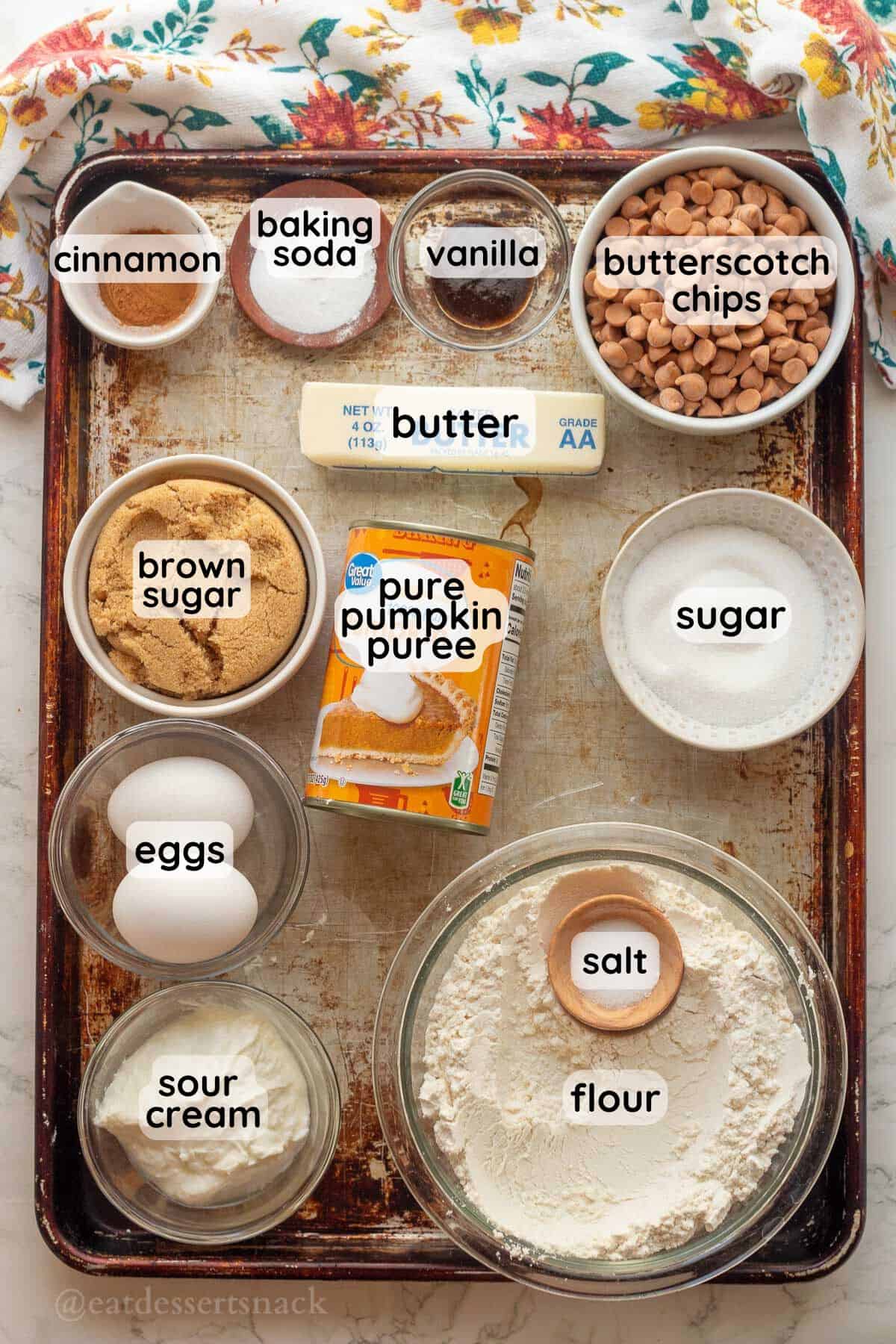 Labeled ingredients for butterscotch pumpkin cake in glass bowls in pan.