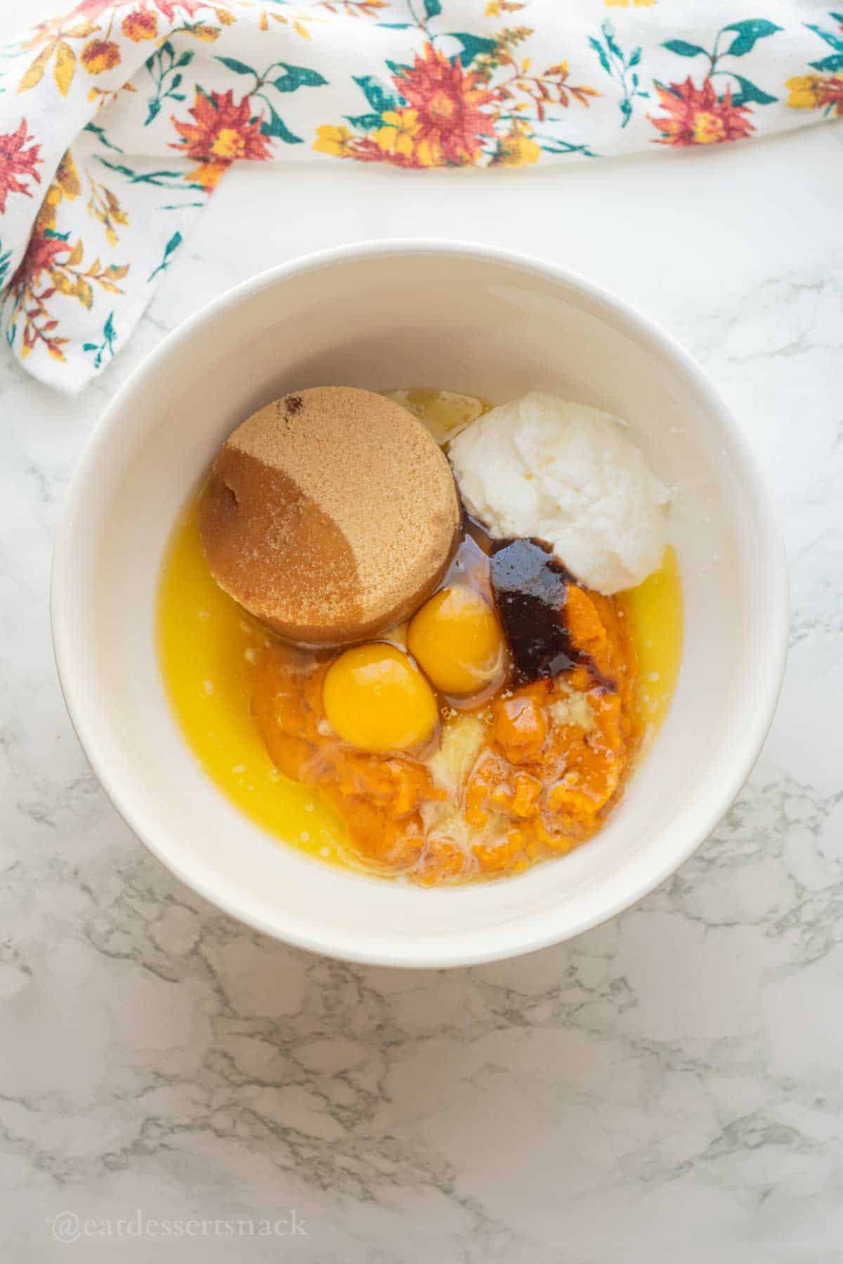 Brown sugar, eggs, pumpkin and greek yogurt in bowl.
