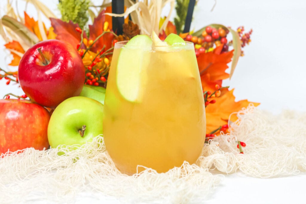 ice fall cocktail with apple slices inside a clear cup