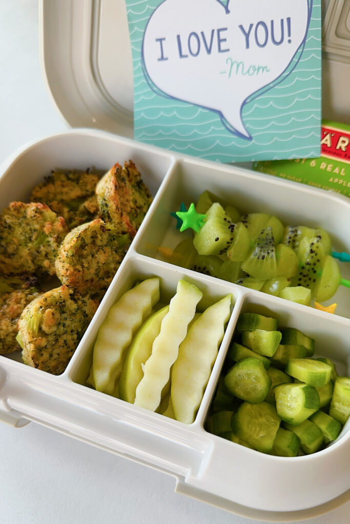 Broccoli bites served with grape and kiwi, apples, and cucumbers.