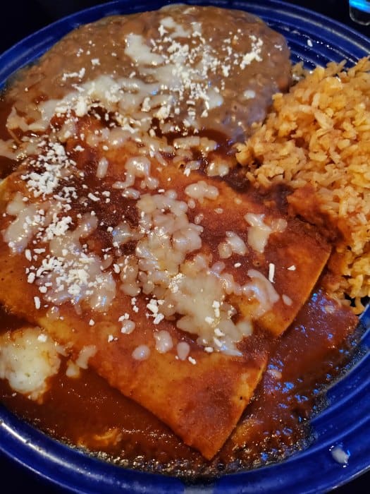 cheese enchiladas and rice on a blue plate