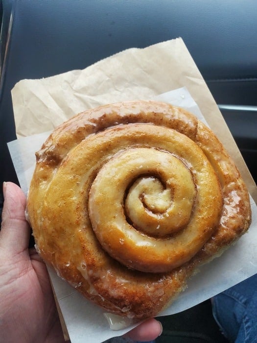 hand holding a cinnamon roll