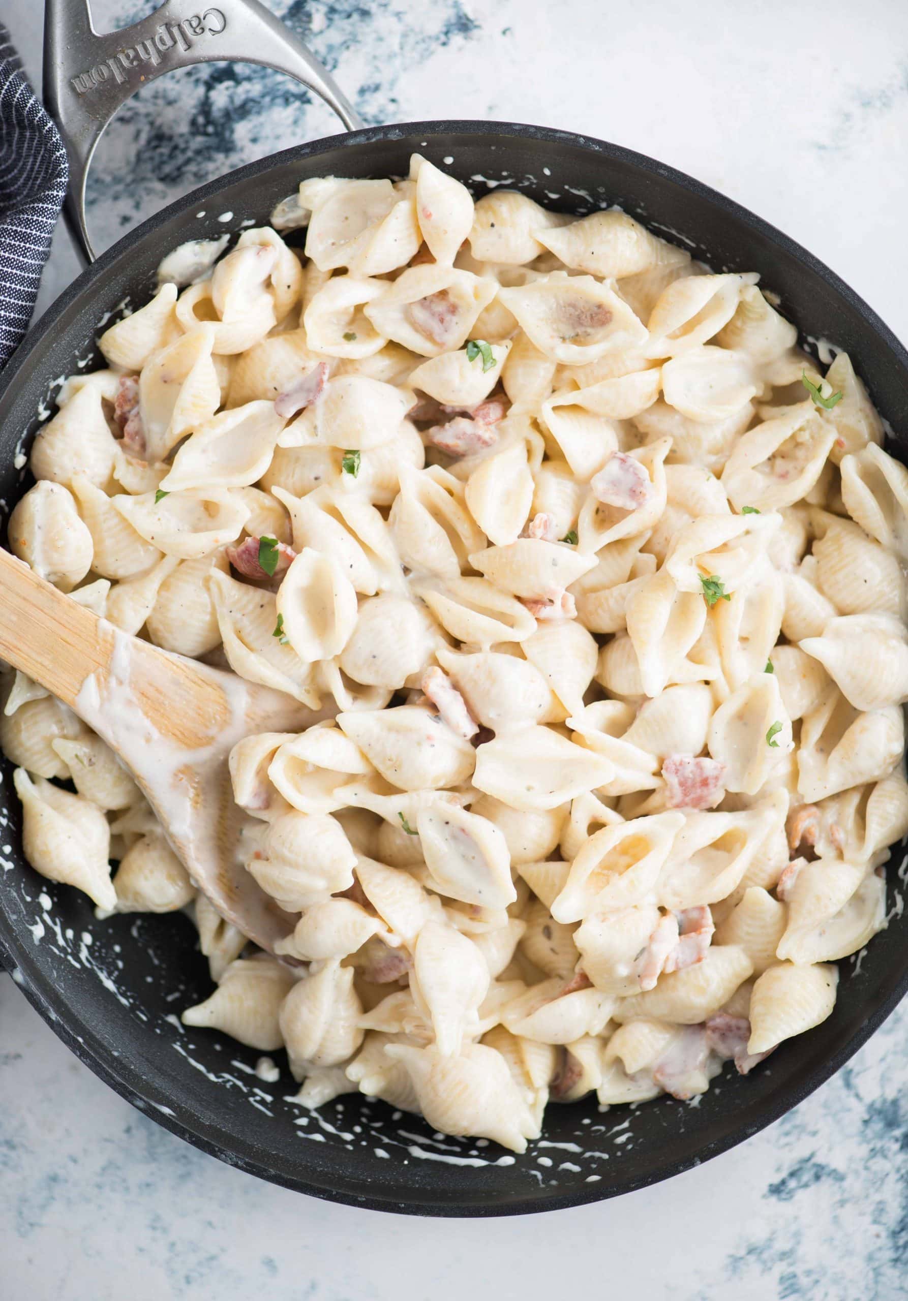 A quick and easy Shell pasta dish in a garlic cream cheese sauce and bacon. Utterly delicious !! This small shell pasta dish can be made in less than 30 minutes. With some wine or protein as sides, this makes a tasty lunch or dinner.
