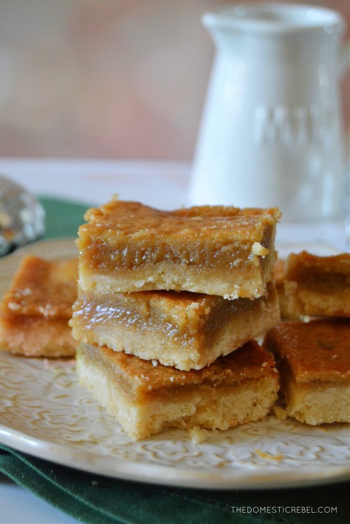 a plate of sugar pie squares on a light background with a milk bottle in the background