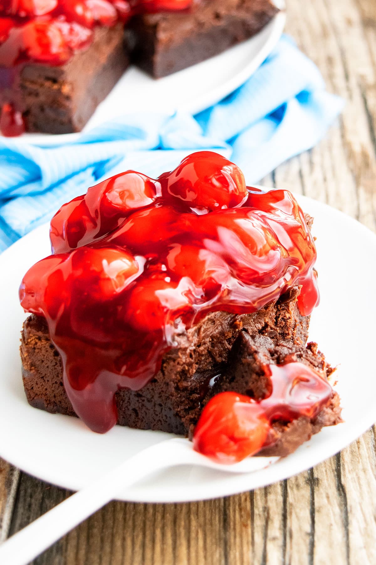 Ooey Gooey Brownies on White Plate and Rustic Wood Background.