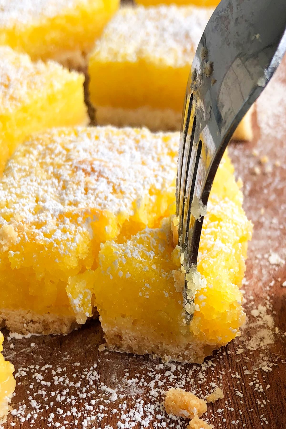 Fork Full of Lemon Dessert on Wood Background. 