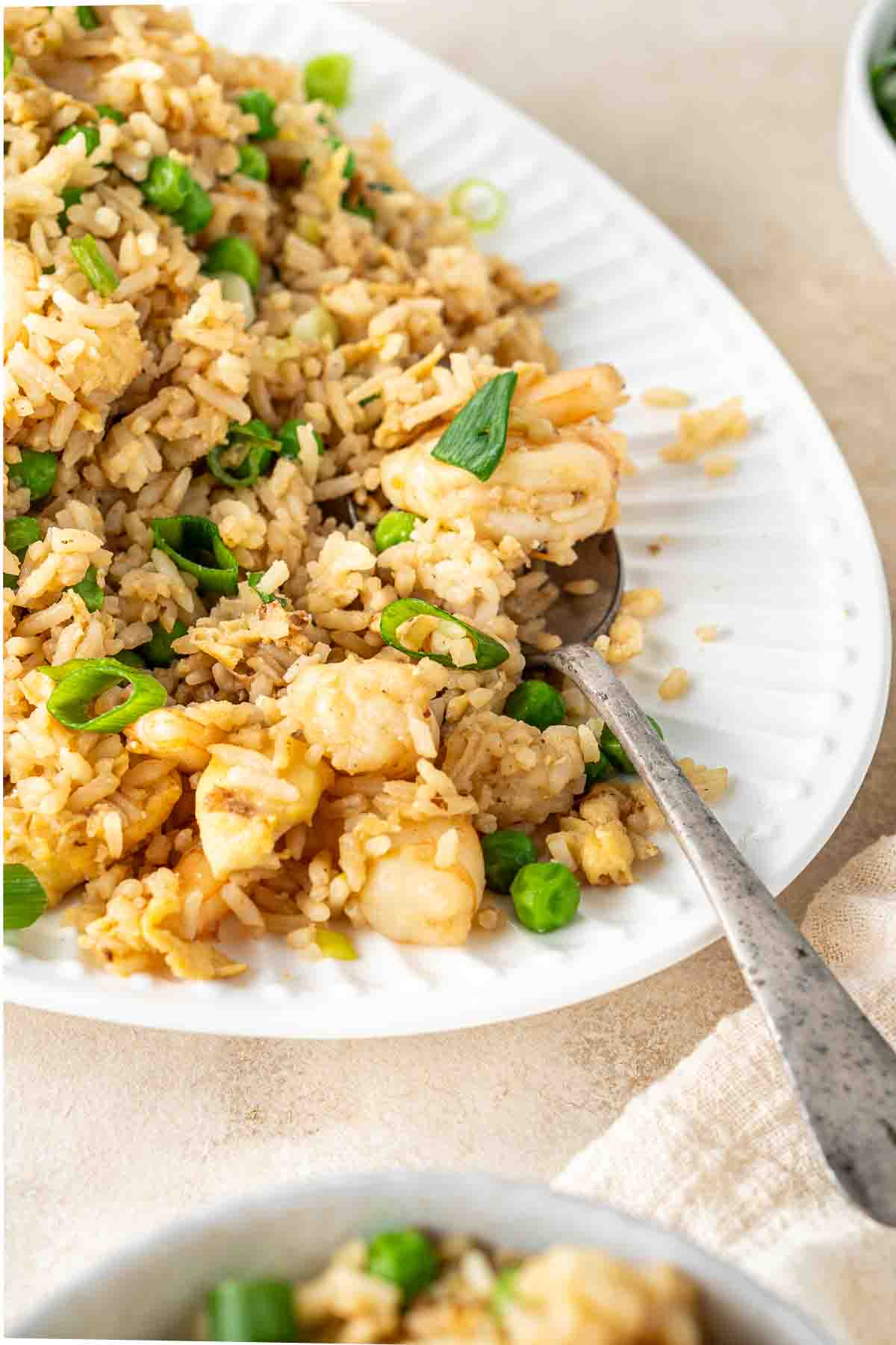 Close up of a spoon serving prawn fried rice.