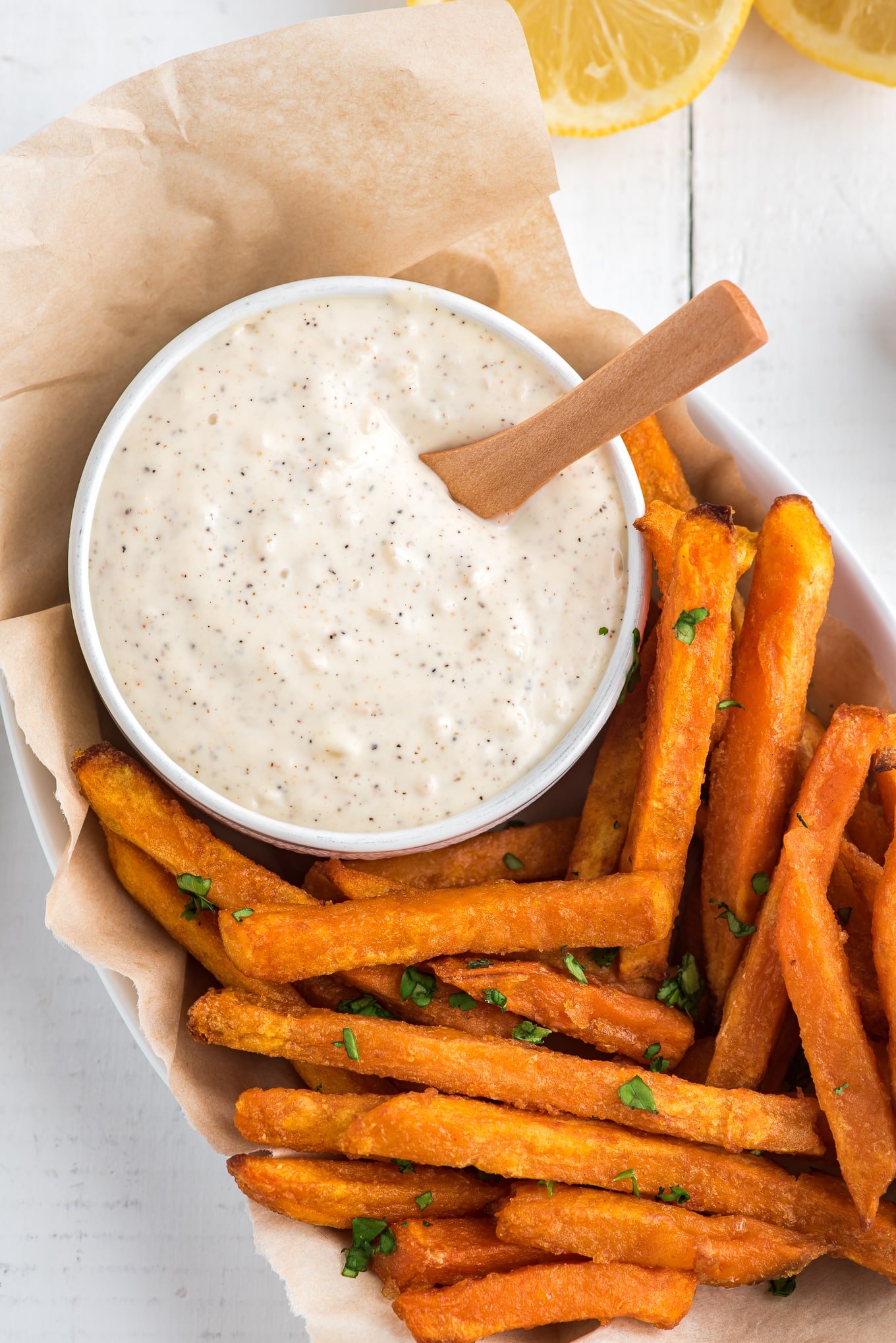 Bowl of lemon garlic aioli in a basket of fries.