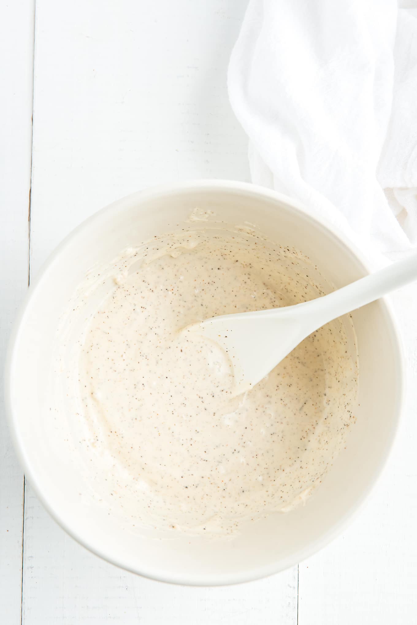 Garlic aioli mayo in a bowl with a spoon leaning inside it.