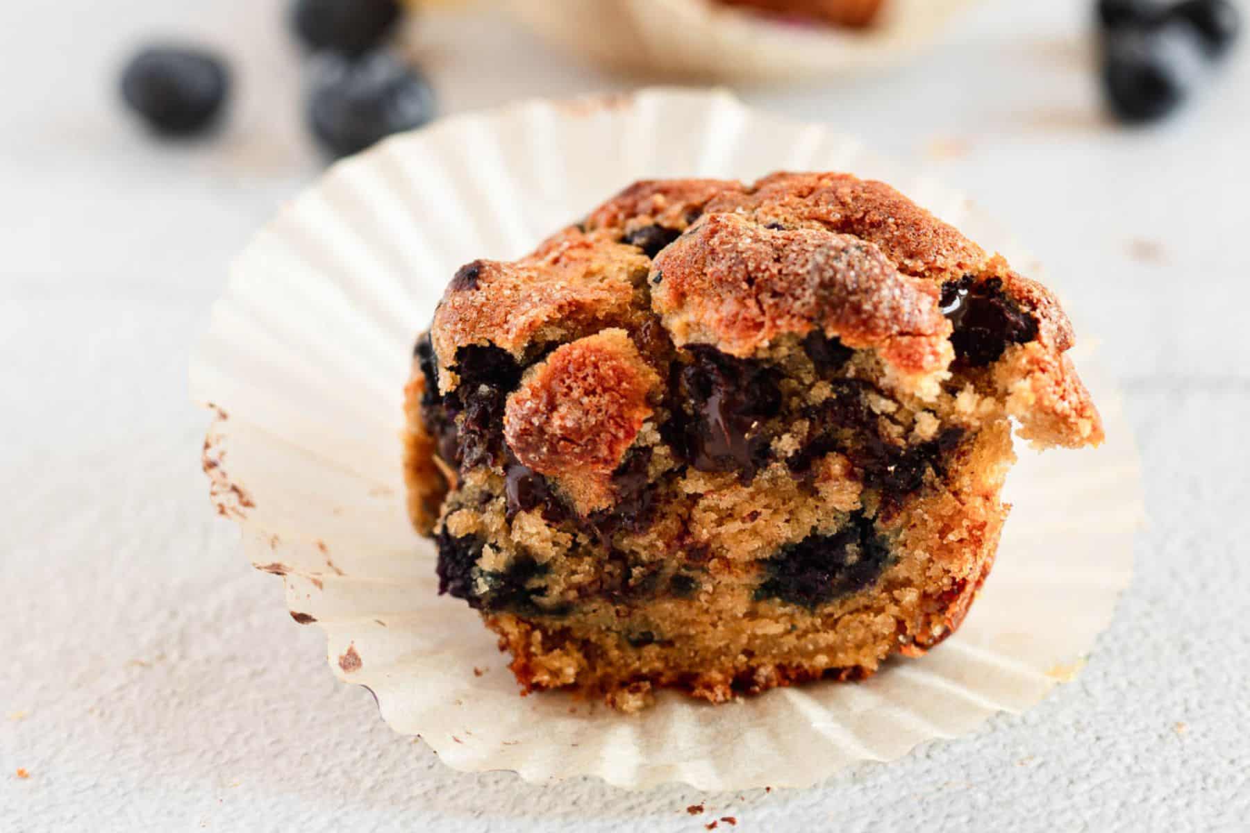 A gluten-free blueberry muffin with a bite taken out of it.
