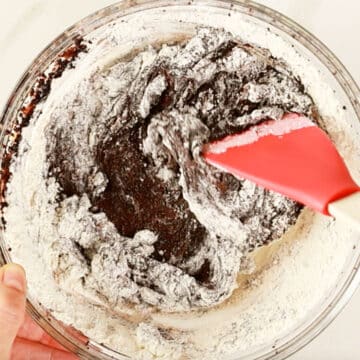 Flour added to batter in glass bowl.