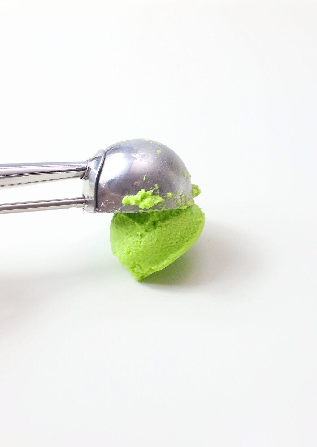cookie scoop putting cookie dough on baking sheet