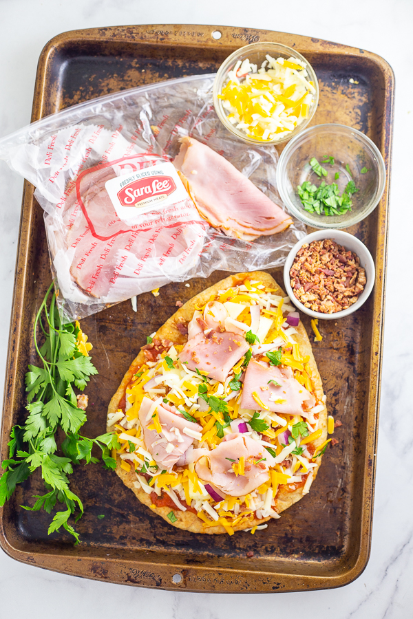 This Flatbread Hawaiian Pizza is quick, easy, and totally delicious! An addicting tangy, salty sweet combination with ham, pineapple, cheese, and a little bacon for good measure. 
