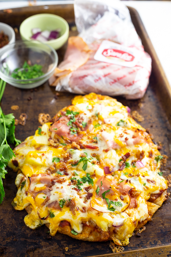 This Flatbread Hawaiian Pizza is quick, easy, and totally delicious! An addicting tangy, salty sweet combination with ham, pineapple, cheese, and a little bacon for good measure. 