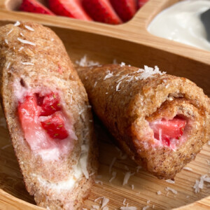 Strawberry cheesecake rollups served with sliced strawberries and yogurt