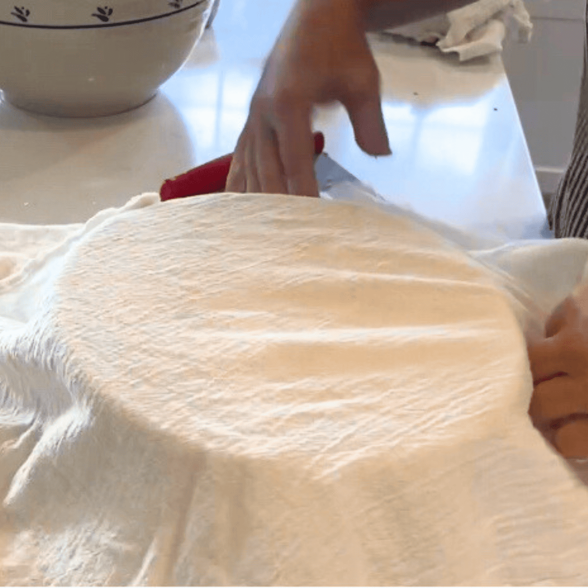 covering Jalapeño Cheddar Sourdough Bread with clean tea towel to rise.