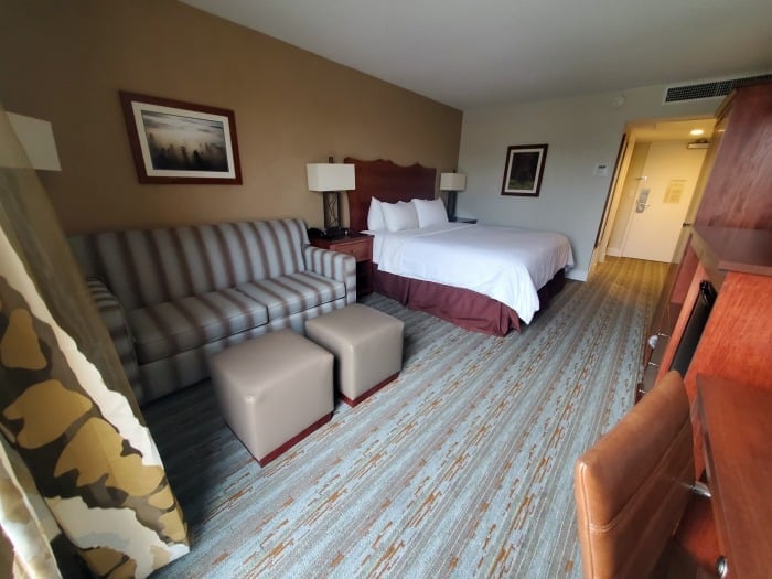 Hotel room wtih a couch, bed, and workspace