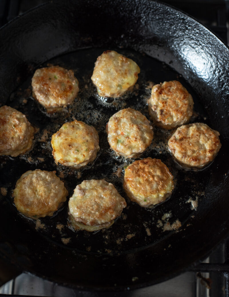 Wanja-jeon patties pan-fried in oil in a skillet until golden brown