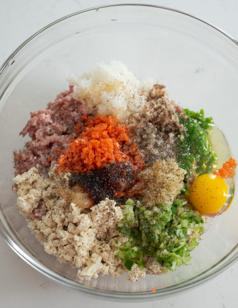 Ground meat, tofu, and minced vegetables mixed in a large bowl