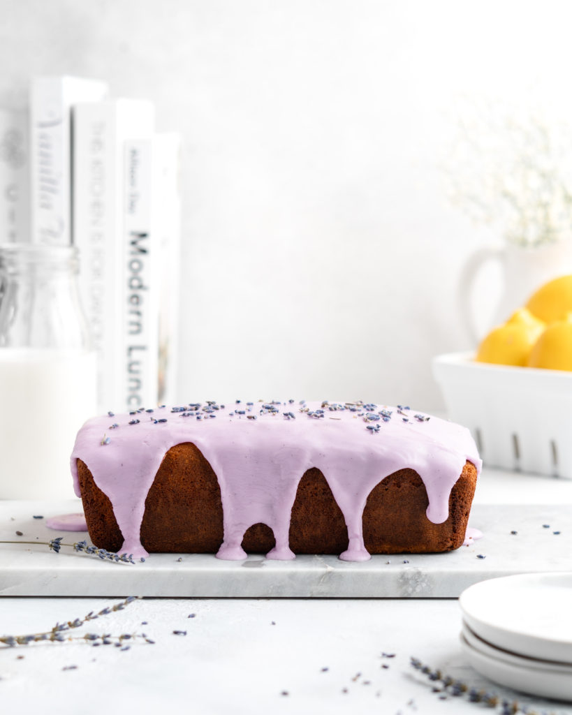 Fluffy and moist Lemon and lavender loaf cake is glazed in a purple coloured vanilla glaze