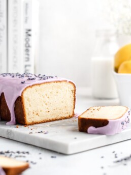 Fluffy and moist Lemon and lavender loaf cake is glazed in a purple coloured vanilla glaze
