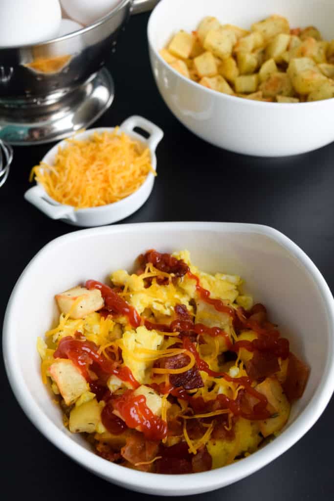 close up view of loaded breakfast bowls with ketchup on top