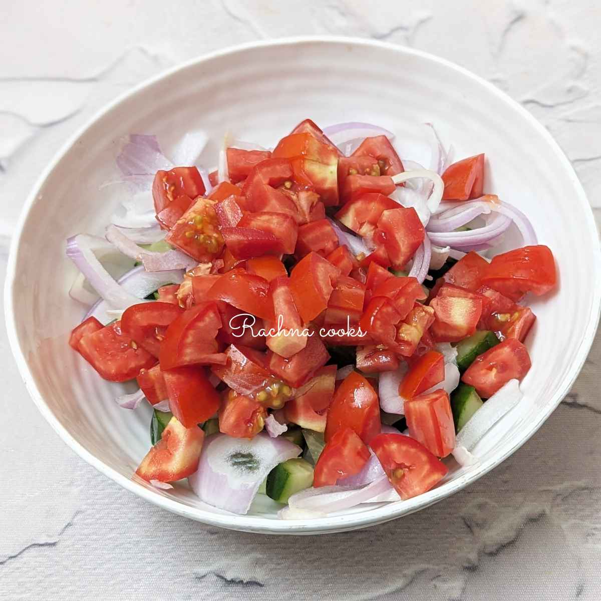 Diced tomato, cucumber and onion in a bowl.