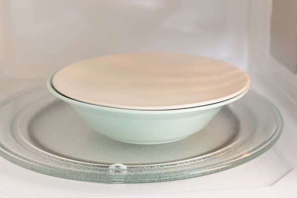 Bowl covered with lid in microwave
