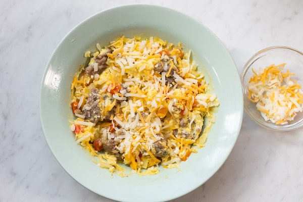 Cheese added on top of cooked eggs and sausage