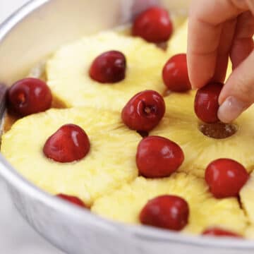 Pineapples and cherries arranged on top the butter mixture. 