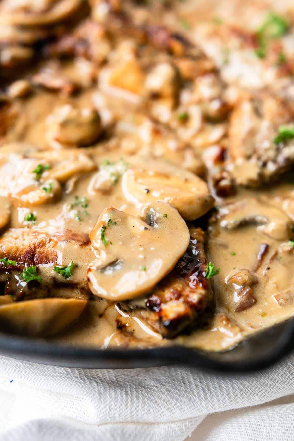 The best pork chops with mushroom sauce. This recipe is a true bistro recipe and fast to prepare. It is on the table in no time. It has the most tasty mushroom garlic bacon sauce. These pork chops will rapidly become your new favorite dinner recipe.