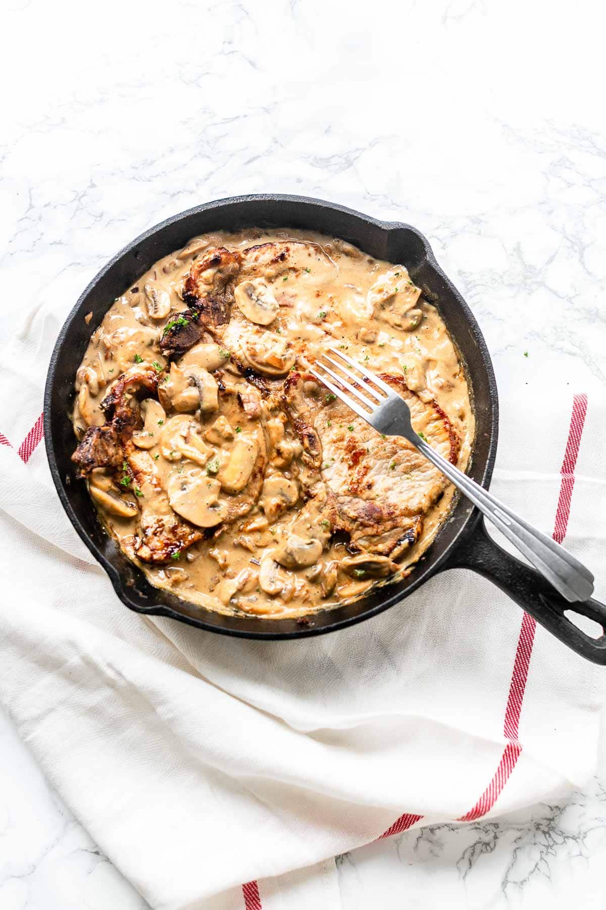 The best pork chops with mushroom sauce. This recipe is a true bistro recipe and fast to prepare. It is on the table in no time. It has the most tasty mushroom garlic bacon sauce. These pork chops will rapidly become your new favorite dinner recipe.