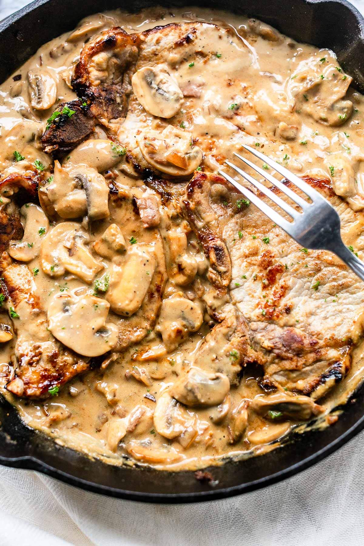 The best pork chops with mushroom sauce. This recipe is a true bistro recipe and fast to prepare. It is on the table in no time. It has the most tasty mushroom garlic bacon sauce. These pork chops will rapidly become your new favorite dinner recipe.