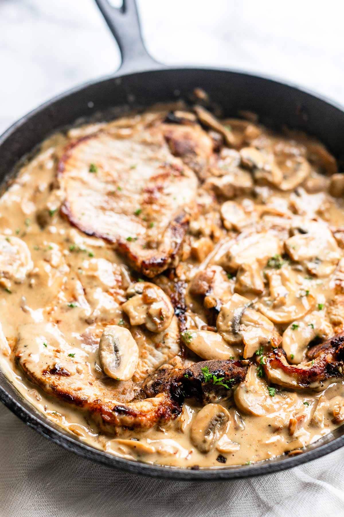 The best pork chops with mushroom sauce. This recipe is a true bistro recipe and fast to prepare. It is on the table in no time. It has the tastiest mushroom garlic bacon sauce. These pork chops will rapidly become your new favorite dinner recipe.