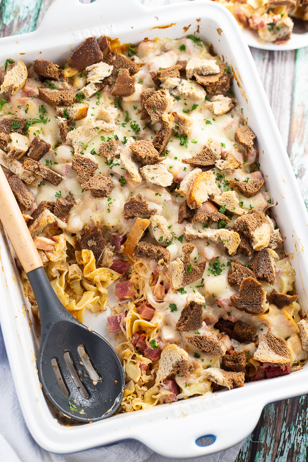 Reuben casserole in ceramic casserole dish on a green rustic wood background