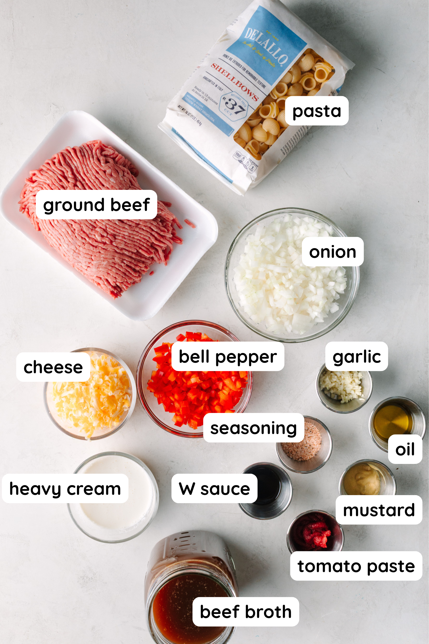 Homemade Hamburger Helper Ingredients: Pasta, ground beef, diced onion, diced bell pepper, shredded cheese, heavy cream, minced garlic, spices, worcestershire sauce, tomato paste, mustard, and oil