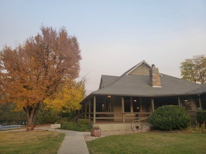 Sierra Sky Ranch entrance with a wagon wheel and fall leaves on the trees